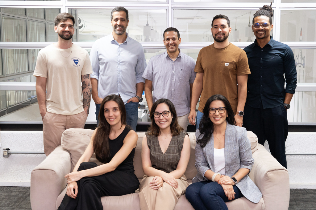 VCRH_95_IA_no_RH_6 Pessoas reunidas para uma foto. Ao fundo, cinco homens de pé. A frente, três mulheres sentadas no sofá.