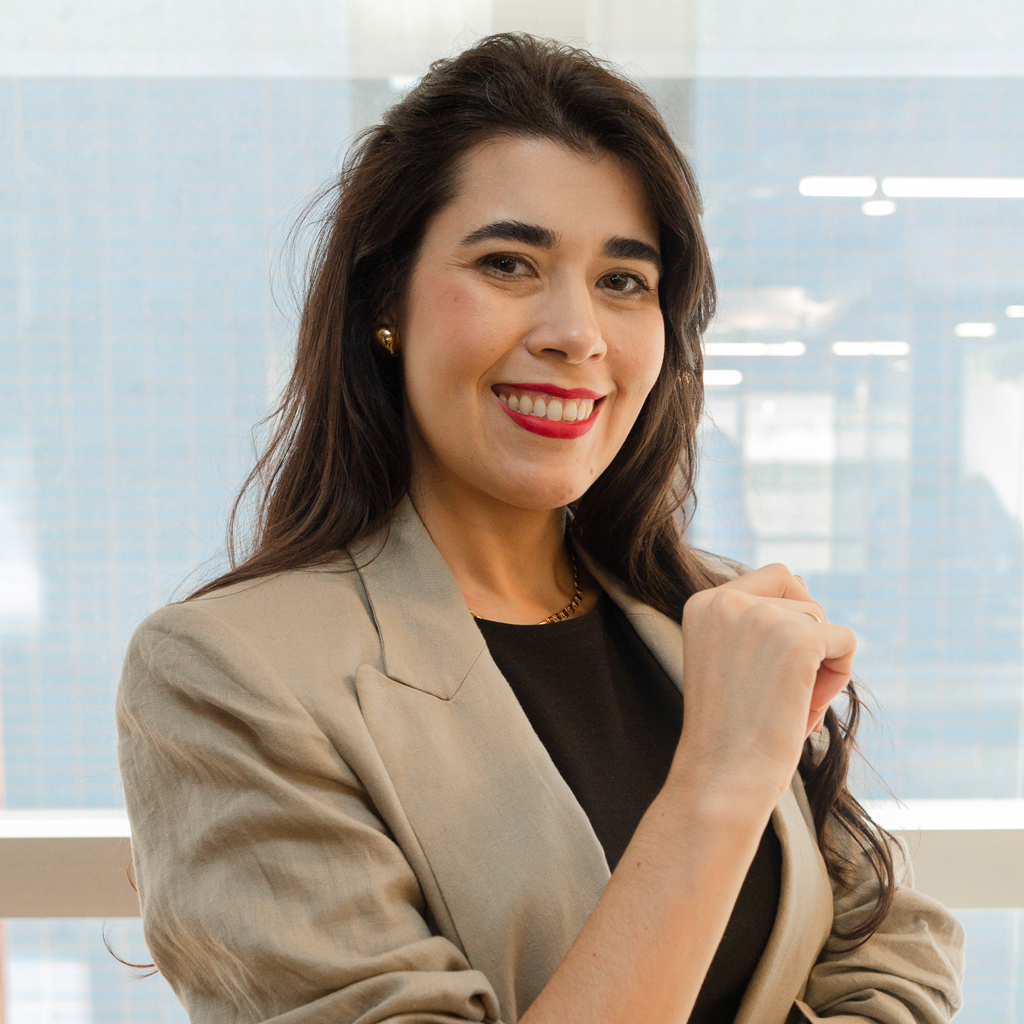 VCRH_96_Assédio_Moral_5 Imagem de uma executiva sorrindo, vestindo um terno caqui.