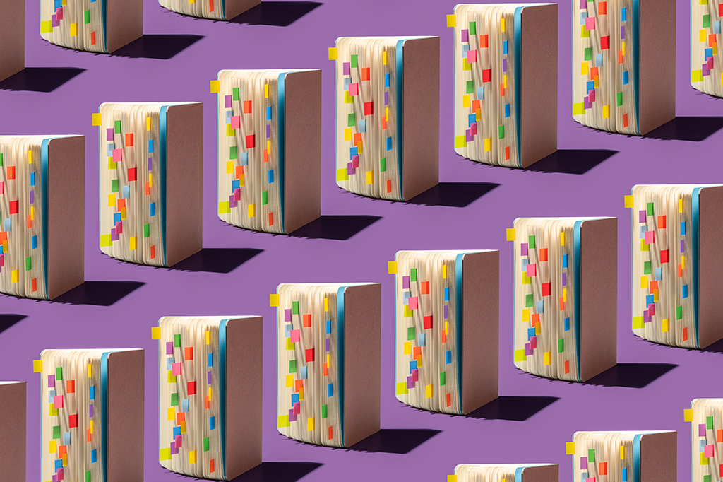 Imagem de livros abertos com padrão de repetição de marcadores coloridos.